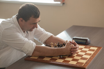 Middle aged Caucasian man playing chess. 