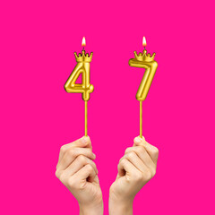 Hands holding number-shaped candles - Birthday number 47