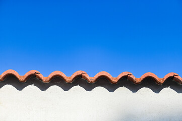 Red tile roof against a bright blue sky