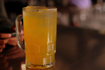 A glass of iced orange juiced with blurred background, A refreshing drink for hot weather
