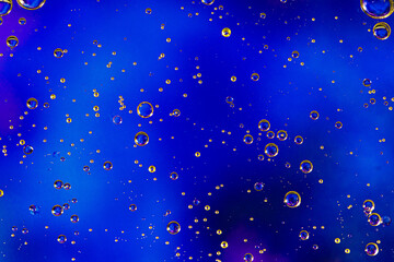 Blue background with oil circles . Bubbles of water. Close up.