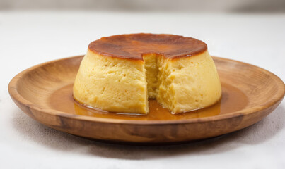 Close-up of Catalan Cream Flan, creamy Spanish dessert served on rustic wooden plate with caramel sauce. Smooth texture, golden-brown top suggest delicious homemade treat, perfect for food blogs,