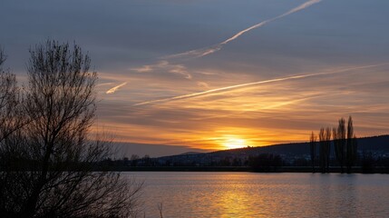 Serene Sunset over Water: The tranquil beauty of a sunset painted across the sky, its warm hues reflected in the calm water, creating a picturesque scene of natural elegance.