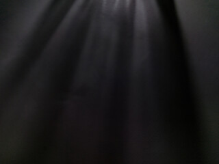 Dramatic light rays pierce through the profound expanse of a dark background, creating an abstract...