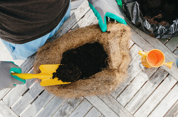 One person plants flowers in an eco-pot in the backyard.