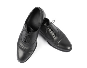 Pair of black leather shoes on white background, top view
