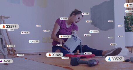 Pouring woman in purple shirt, leggings tilting paint can into tray at home, with floating icons