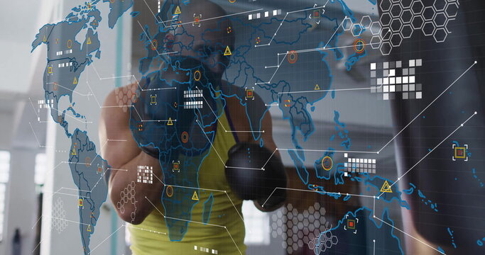 Punching trainee wearing green top, black gloves striking heavy bag at gym, with digital overlay - Powered by Adobe