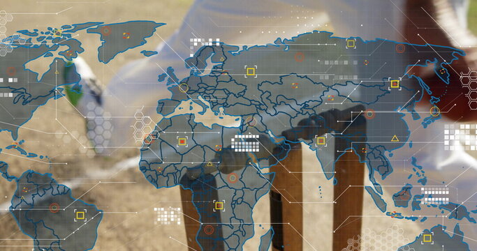 Digging man in jeans, boots planting guarded sapling with shovel in field, digital map, copy space - Powered by Adobe