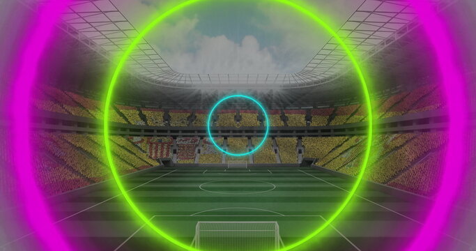 Fans in jerseys and T-shirts holding cards forming mosaic in stadium, soccer goal and neon rings - Powered by Adobe