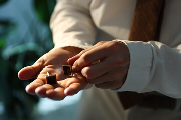 Man with cufflinks getting ready indoors, closeup