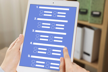 Woman passing online test on tablet computer in office, closeup