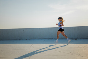 Dynamic woman jogging along a sunlit outdoor track