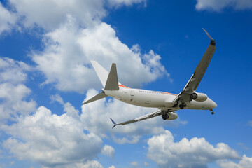 Airplane flying in beautiful blue sky with clouds