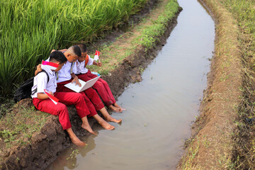 Students In Uniform Engaging With Technology While Showing Patriotism Outdoors