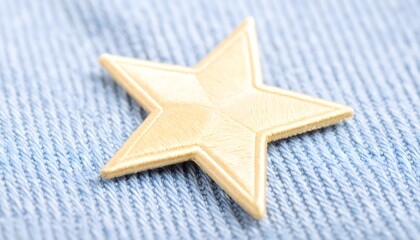Close-up of gold star patch on dark denim fabric.