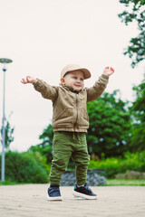 A cheerful and exuberant toddler is happily playing outdoors, arms spread wide in a beautiful...
