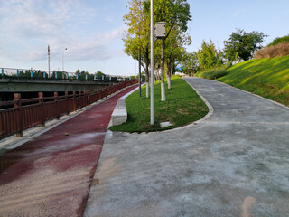 riverside trail with wooden fence and dirty ground after rainfall in modern city,Concept of urban infrastructure