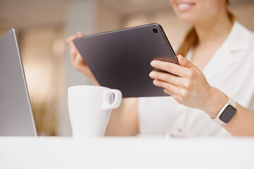 A young professional works efficiently at a sleek desk with a modern tablet and laptop boosting...