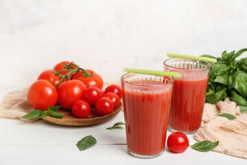 Glasses of tasty tomato juice on table