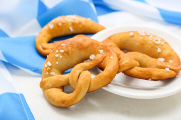 Plate with soft pretzels and flag of Bavaria on white background