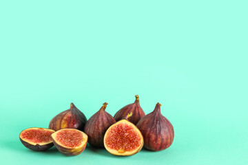Fresh juicy cut figs on turquoise background