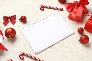 Blank paper calendar with gift boxes and Christmas decorations on white background