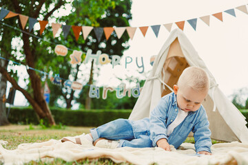 An adorable baby is joyfully celebrating their birthday surrounded by colorful decorations in a...