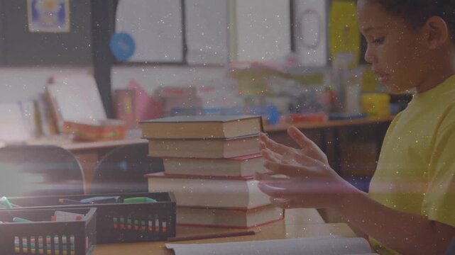 Boy bringing hands above notebook and flexing fingers for counting near textbook stack in education