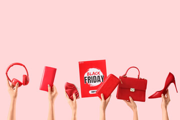 Female hands with stylish accessories, headphones and text BLACK FRIDAY SALE on pink background
