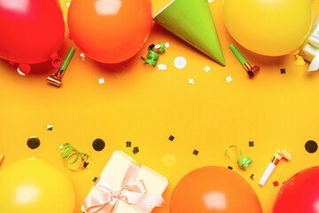 Balloons with gift, party whistles and confetti on yellow background