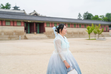 In Seoul in June 2025, a Korean woman in her twenties walks in front of the traditional facade of...