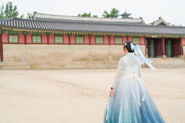In Seoul in June 2025, a Korean woman in her twenties walks in front of the traditional facade of...