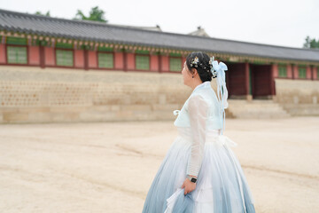 In Seoul in June 2025, two Korean women in their twenties wear pink and sky-blue hanbok as they...