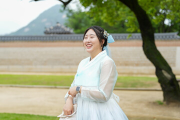 In Seoul in June 2025, two Korean women in their twenties wear pink and sky-blue hanbok as they...
