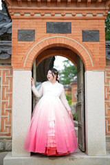 In Seoul in June 2025, two Korean women in their twenties wearing pink and sky-blue hanbok stand in...
