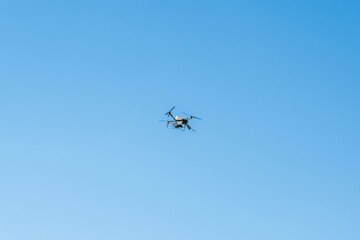 Drone flying in clear blue sky with no clouds