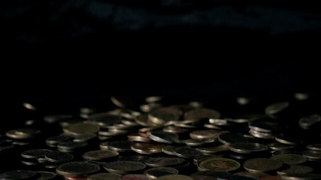 falling coins falling in slow motion on dark background