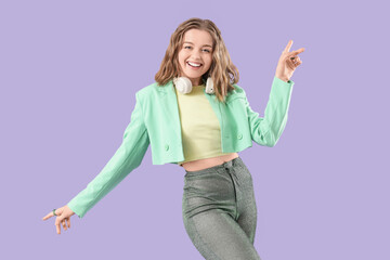 Cool young woman dancing on lilac background