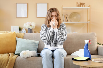 Young woman suffering from allergy while cleaning flat