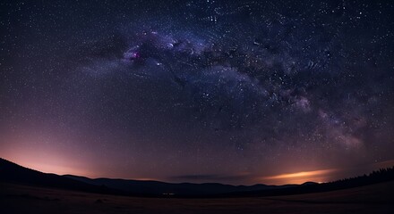 Naklejka premium Vast night sky filled with stars and the milky way over a landscape.