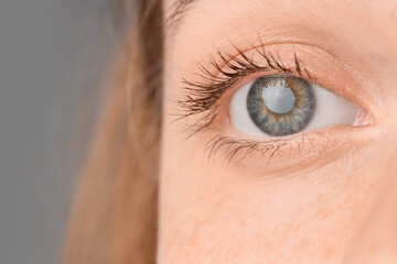 Woman with beautiful green eyes on dark background, closeup