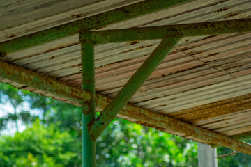 Rusted metal scaffolding supports a corrugated metal roof