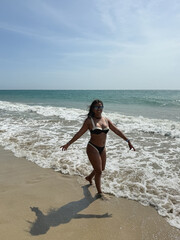 Young woman walking on the beach enjoying summer vacation