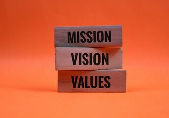 Mission, Vision, and Values Concept with Wooden Blocks on Orange Background