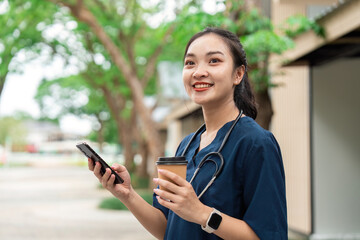 Doctor enjoying coffee break while using smartphone outdoors