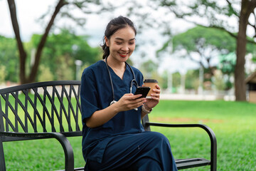 Doctor enjoying coffee break while using smartphone in park