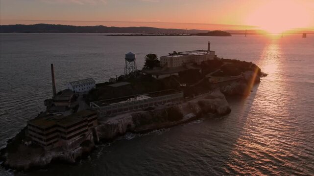 Alcatraz Island, USA, at sunset. The former prison is now a popular tourist destination, offering tours and historical insights. The sun sets over the bay.