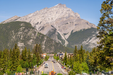 Majestic Mount Rundle overlooks Banff's vibrant downtown on a sunny day