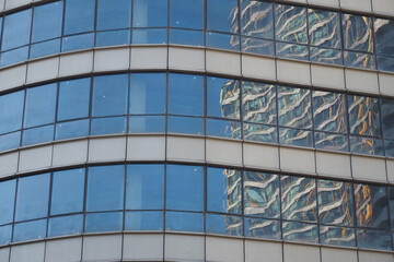 Reflective glass building shows neighboring architecture